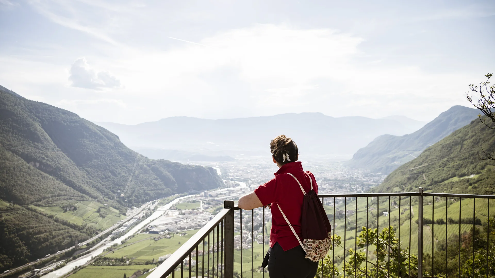 Bilder vom Armonia: Hof am Ritten in Südtirol Wanderin blickt von einem Aussichtspunkt über ein Tal zwischen bewaldeten Bergen