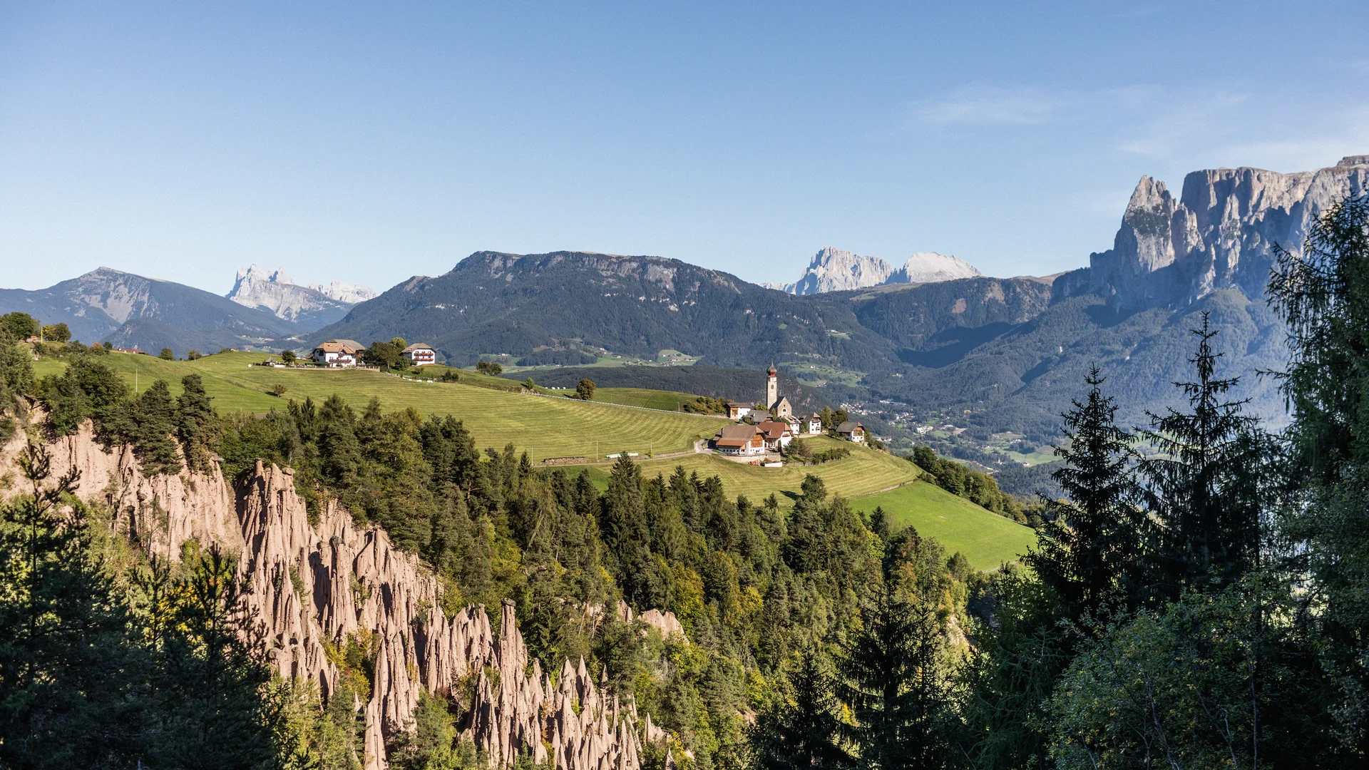 Bilder vom Armonia: Hof am Ritten in Südtirol Blick auf Erdpyramiden, ein Dorf auf grünen Hügeln und die Dolomiten