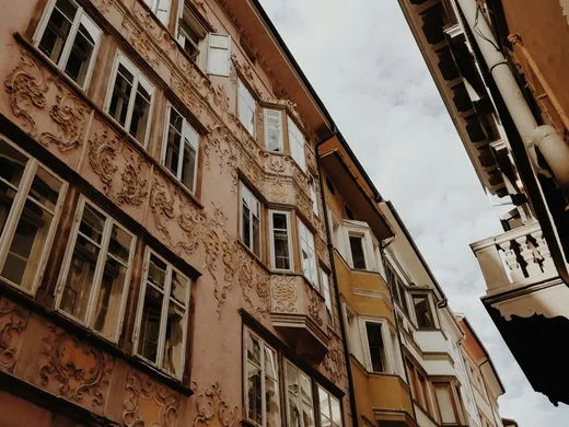 Urlaub am Ritten: die Insider-Tipps des Armonia Blick nach oben auf verzierte Altbaufassaden in einer engen Gasse